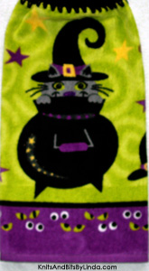 grey cat in black cauldron on halloween kitchen towel